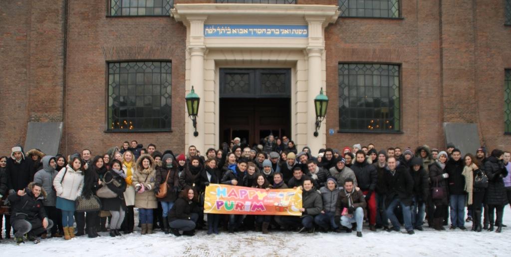 Joodse jongeren uit heel Europa poseren gezamenlijk voor de Esnoga in Amsterdam bij het ECJS Poeriem weekend.